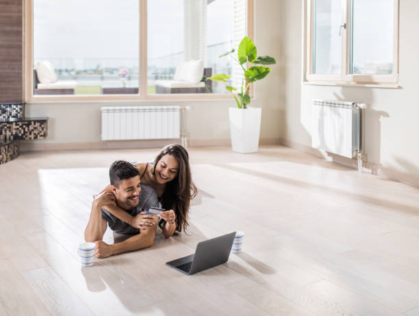 istock Loving couple having fun while shopping online for their new apartment. 803667762