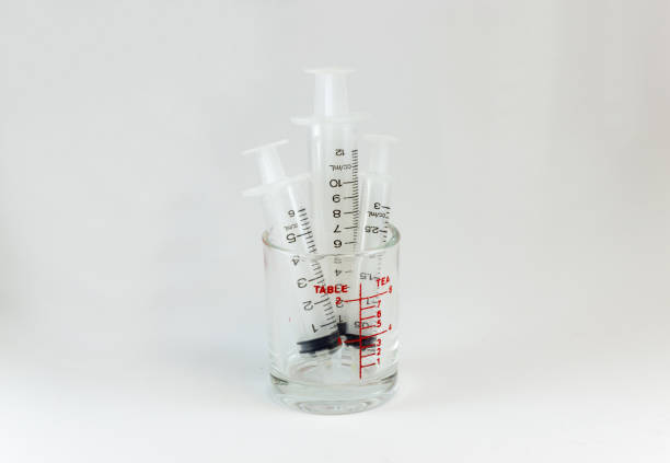 istock plastic medical syringes in medicine glass 803670416