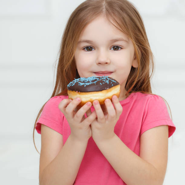 istock Adorable little girl with a chocolate donut 803677906