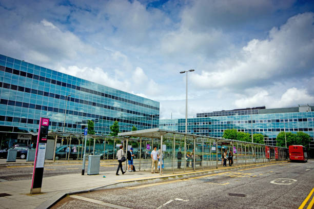 Milton Keynes Office Buildings Milton Keynes, UK Jul 16. Reflective mirror glass on the building exteriors of Office Blocks above Milton Keynes Central Station with cloud reflections. This was used as Metropolis in Superman films because of its futuristic look. The sign above the entrance is visible at the bottom of shot. This is the plaza outside the station with people waiting for buses and walking across the pedestrian area. superman named work stock pictures, royalty-free photos & images