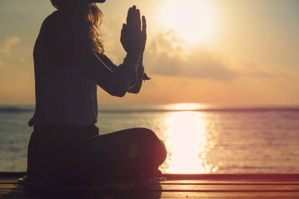 istock Woman practicing yoga on the beach. 803690072