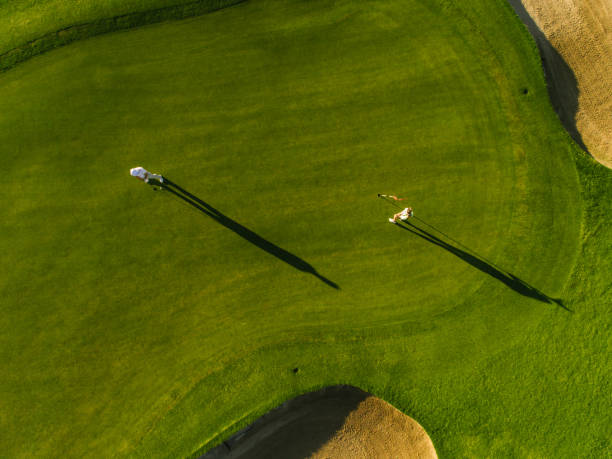 istock Aerial view of golfers playing on course 803690448