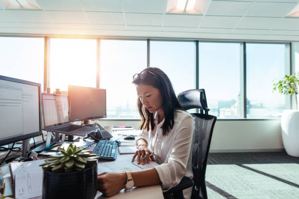 woman entrepreneur at work in office. - desk corporate business business paper imagens e fotografias de stock