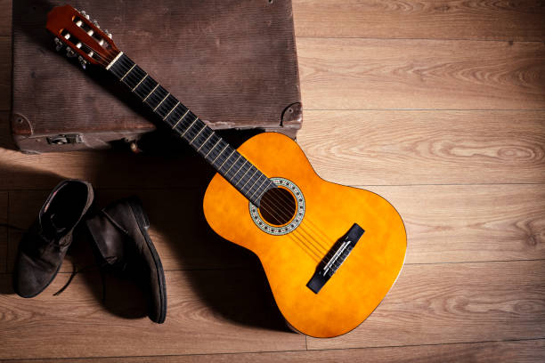 istock Up side view of guitar with old boots and suitcase 803693600