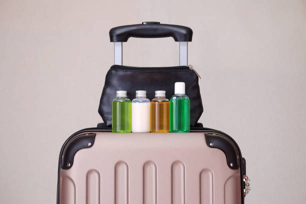 articles de toilette, petites bouteilles en plastique de produits d’hygiène sur la valise de voyage - article de toilette photos et images de collection