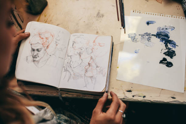 istock Female artist looking at sketches in her studio 803699022