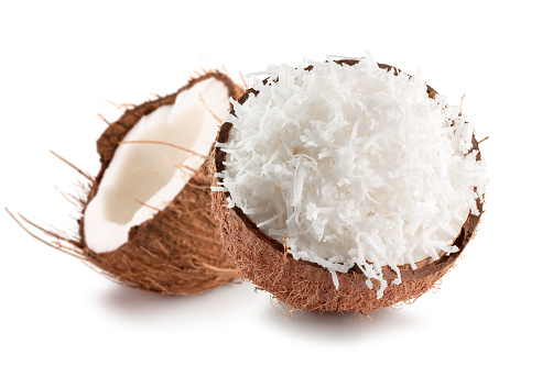 two halves of coconut with coconuts flakes isolated on a white background.