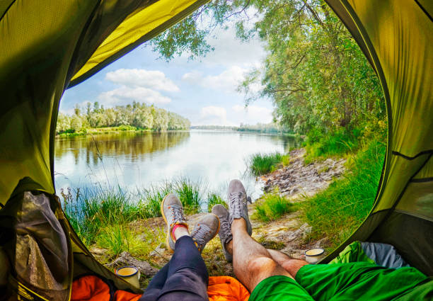 istock Young couple sitting   in the tent  while looking on the Desna river 803702690