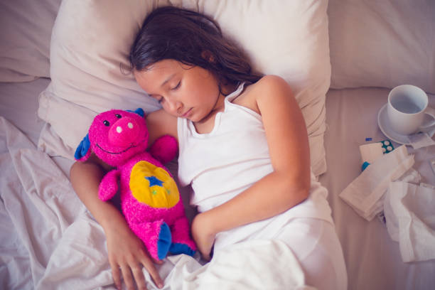 istock Kid girl sleeping and sick on the bed with doll 803714566