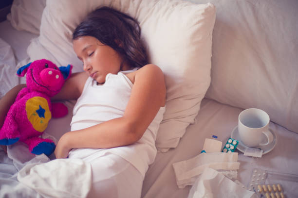 istock Kid girl sleeping and sick on the bed with doll 803720378