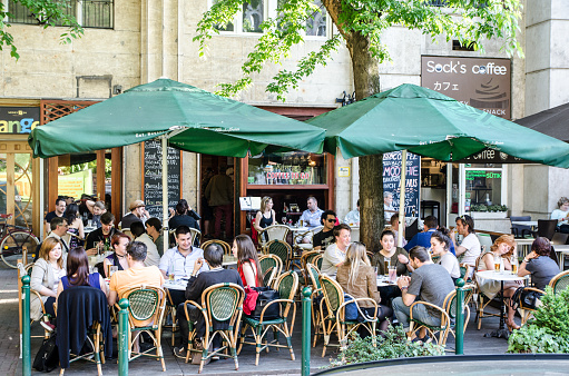 Crowd of customers sitting at a patio restaurant in Budapest during summer day