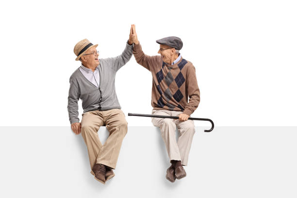 istock Seniors sitting on a panel and high-fiving each other 803721420