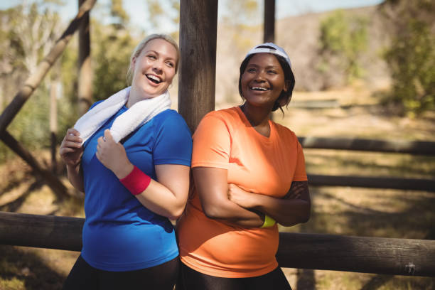 istock Happy friends standing with arms crossed during obstacle course 803721686