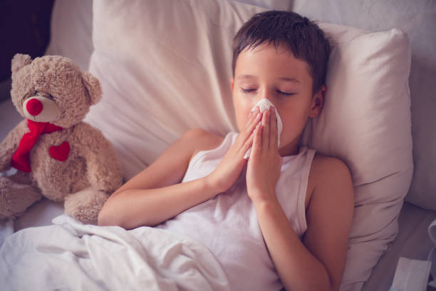 istock Portrait of a sick boy cleaning his nose 803729362
