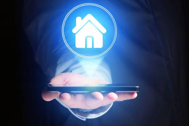 istock Businessman hand holding mobile phone with home icon 803743262