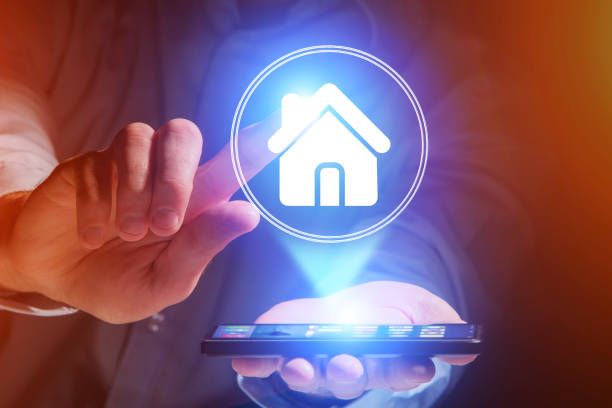 istock Businessman hand holding mobile phone with home icon 803748338