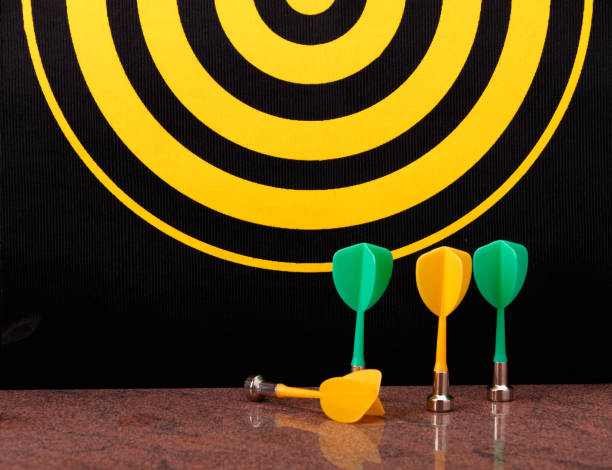 istock Magnetic dart arrows on granite surface and dart board background. 803785034