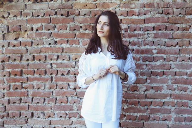 istock Young woman portrait against a brick wall 803811864