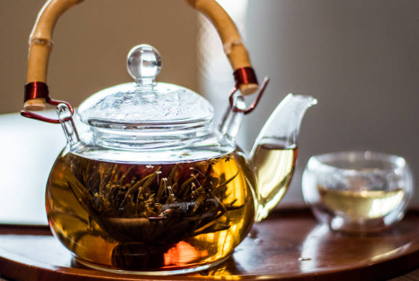tè al gelsomino in una tradizionale teiera di vetro con una maniglia di bambù a shanghai, cina - chinese tea teapot isolated tea foto e immagini stock