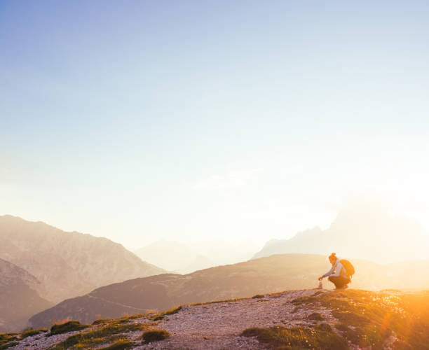 istock Female silhouette finding her inner peace in breathtaking mountain environment during sunrise 803821846