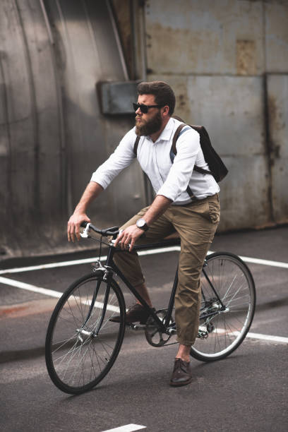 istock serious stylish bearded man in sunglasses riding bicycle 803829590