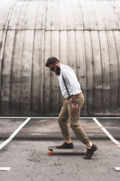 istock stylish handsome man in white shirt with longboard on parking place 803829632
