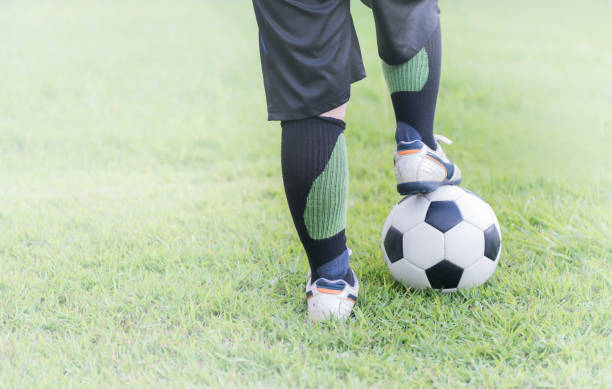 istock soccer ball with child feet player on green grass 803858210