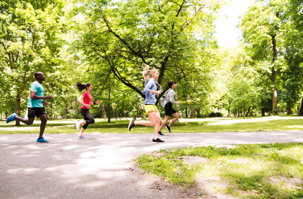 istock Group of young athletes running in green sunny park. 803859450