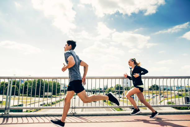 istock Young couple in the city running on a bridge. 803859934