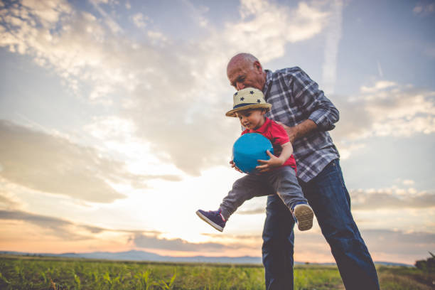 Fun and happy family times Grandfather and grandson playing with a ball and having fun together grandfather stock pictures, royalty-free photos & images