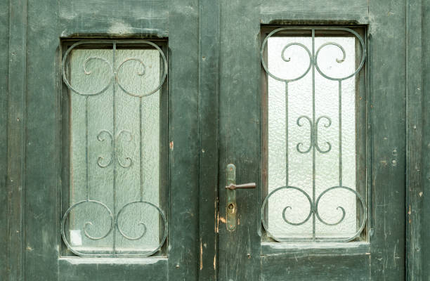 istock Old black wooden doors with glass windows and metal details. 803866176
