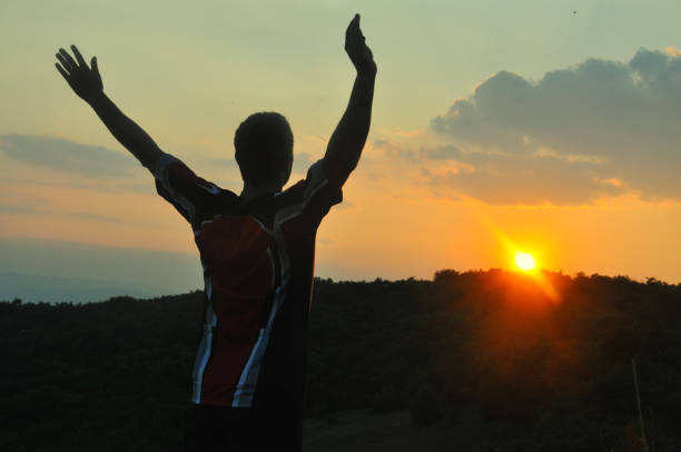istock The man raised his hands and enjoys in beautiful sunset. 803866356