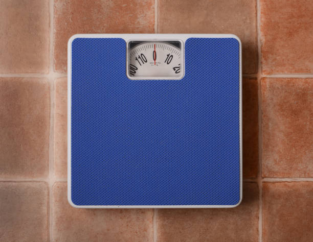 istock Bathroom scale isolated on terracotta floor background 803871944
