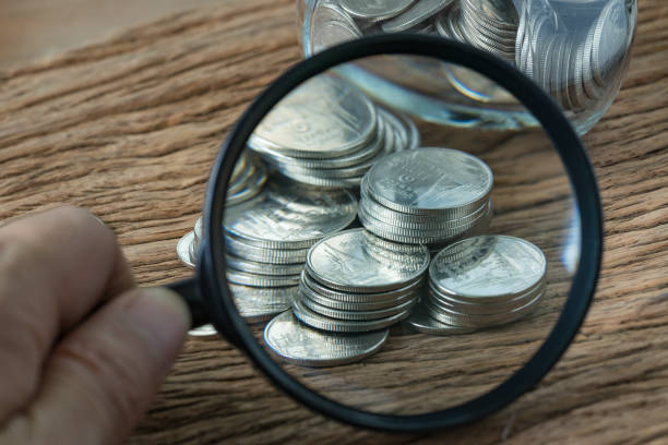 enfoque selectivo en pila de monedas a través de la lupa de mesa de madera como financieros de ahorro o analizar el concepto - scrutiny paper currency european union currency magnifying glass fotografías e imágenes de stock