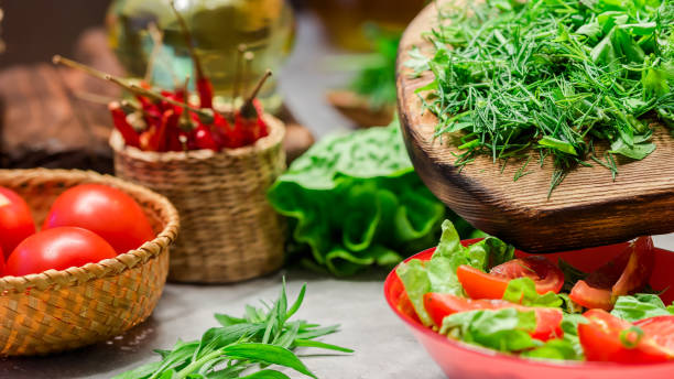 Fresh vegetable salad cooking Adding chopped herbs into the bowl with fresh vegetable salad. Close up tarragon cutting board vegetable herb stock pictures, royalty-free photos & images