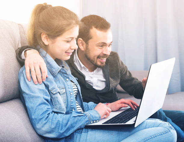 istock Father and daughter booking hotel online 803894942