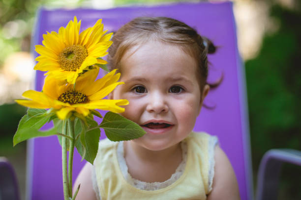istock Baby toddler with Sunflowers 803902366