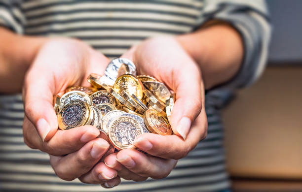 英国のコインを保持しています。 - one pound coin ストックフォトと画像