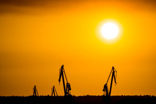 istock Landscape of a cranes in a harbor at sunset with clouds 803916690