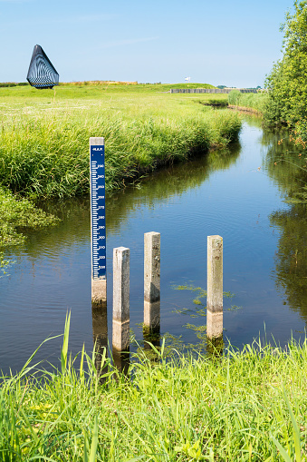 Water level staff gauge in ditch in polder Schokland, Noordoostpolder, Flevoland, Netherlands