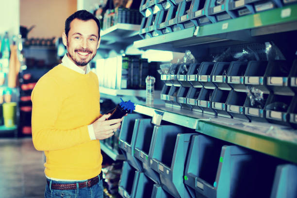 istock Man choosing various tools in garden equipment shop 803920462