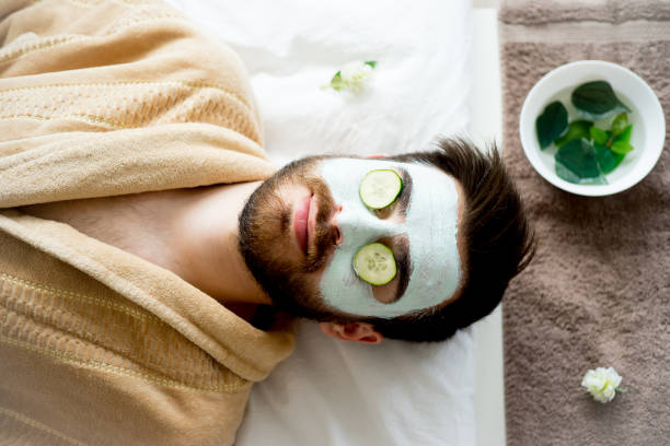 hombre con una máscara de arcilla - mud wellbeing spa treatment beautician fotografías e imágenes de stock