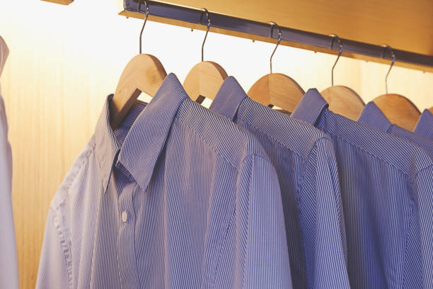istock blue clothes hanging on a rack in a row 803925932