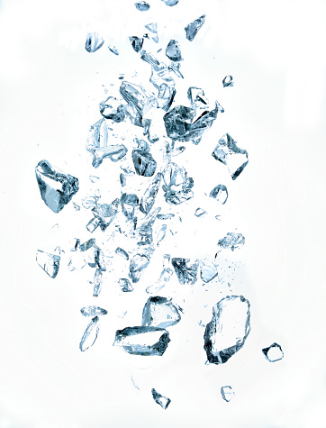 Falling or exploding broken crystals on white background, studio shot.