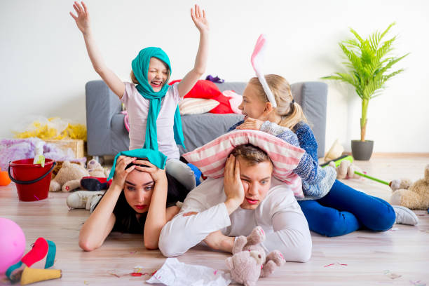 istock Tired parents and romping kids 803940280