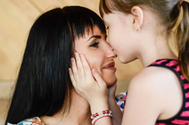 10 歳の少女の鼻の中の母親をキスします。 - 10 11 years child little girls offspring ストックフォトと画像