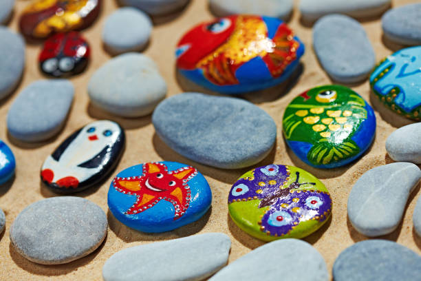 istock Rounded colorful stones pebbles shingle with pictures painted on them 803944292