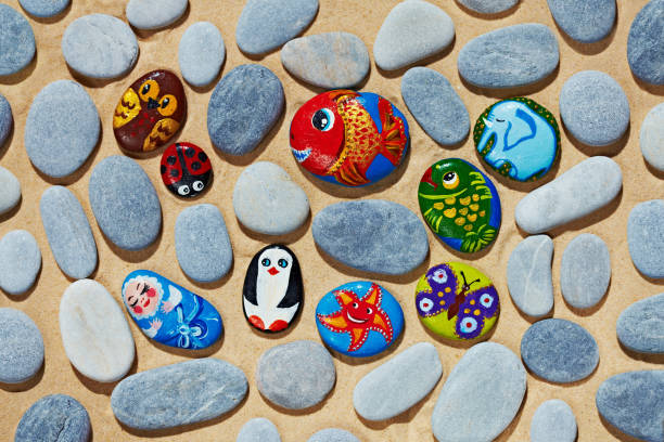 istock Rounded colorful stones pebbles shingle with pictures painted on them 803944738