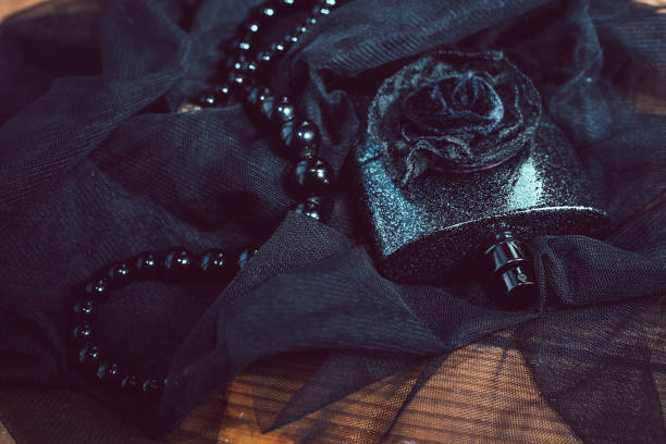 istock women's perfume in beautiful bottle and beads, on black background 803952840
