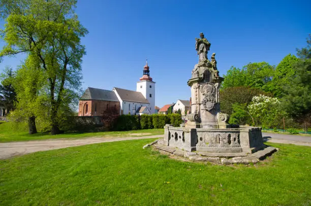 Old statue and church in Tyniec nad Sleza village, Poland